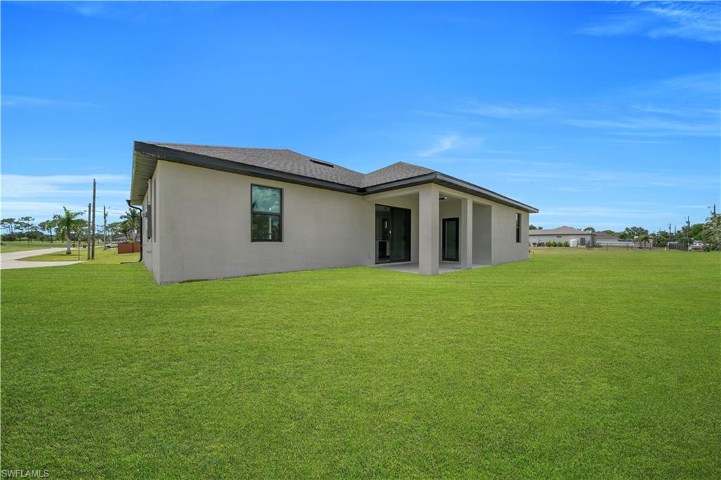 Modern stucco exterior featuring a dark asphalt shingle roof and a covered entry