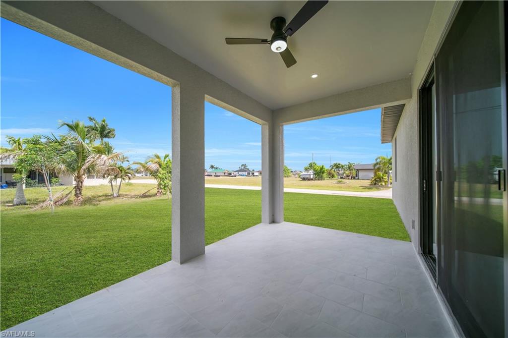 Covered patio with a ceiling fan and recessed lighting, featuring tiled flooring and a sliding glass door