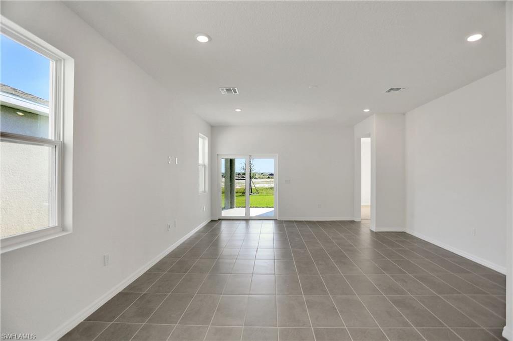 Unfurnished room featuring recessed lighting and dark tile patterned floors