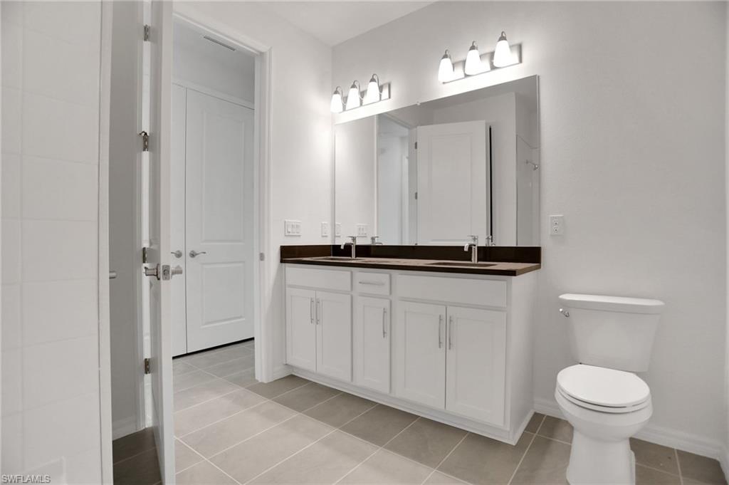 Bathroom featuring double vanity and light tile patterned floors