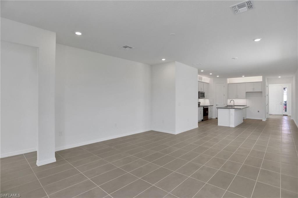 Unfurnished living room with recessed lighting and light tile patterned floors