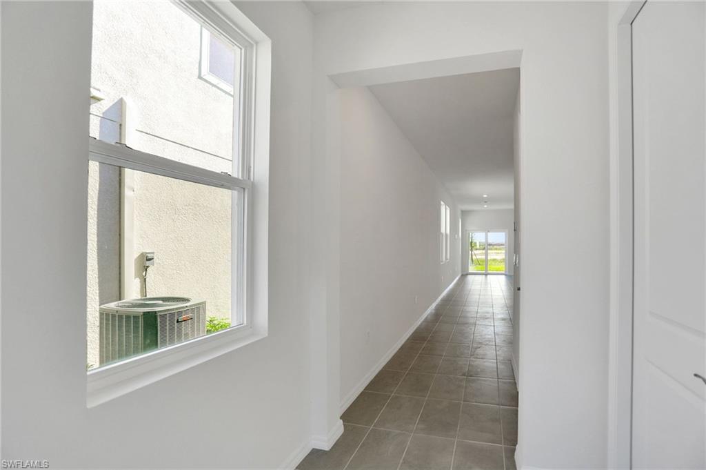 Hallway with plenty of natural light and light tile patterned flooring
