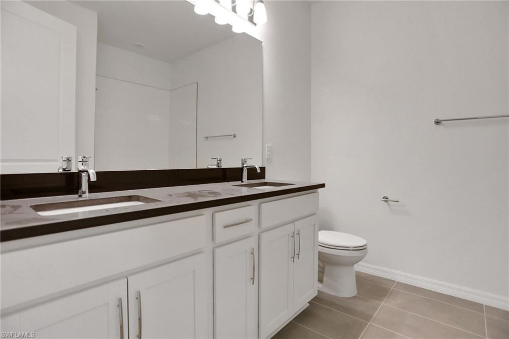 Full bathroom featuring double vanity and light tile patterned floors