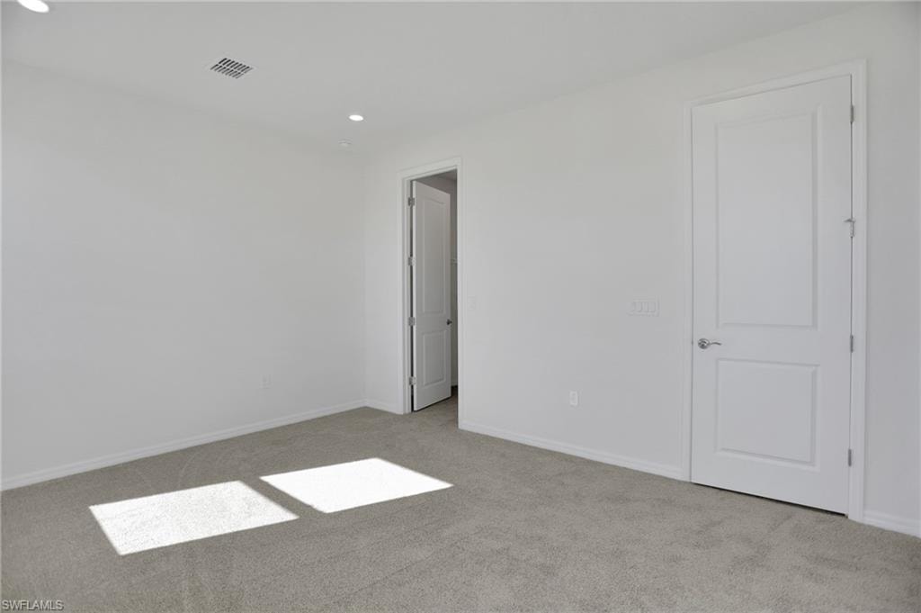 Unfurnished bedroom featuring light colored carpet and recessed lighting