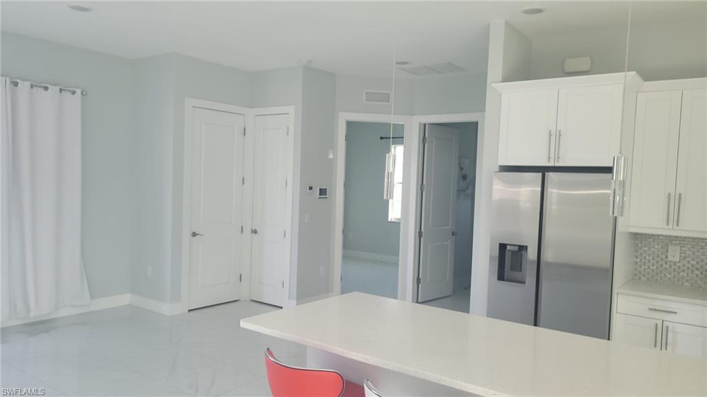 Kitchen with white cabinetry and stainless steel refrigerator