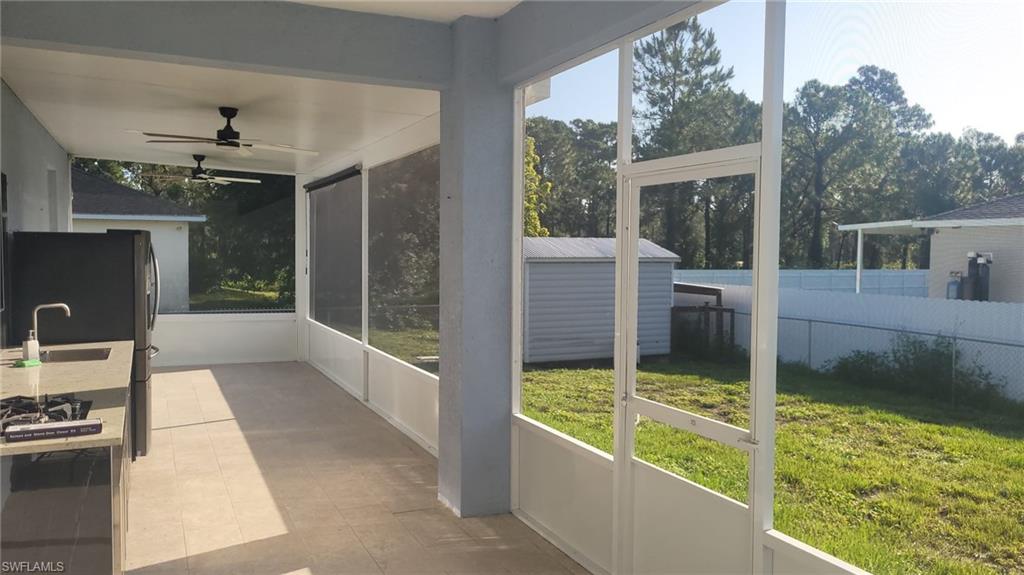 Screened patio featuring an outdoor kitchen with countertop, built-in sink, and range