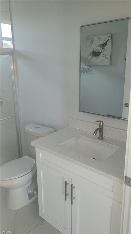 White vanity with a light-toned countertop, under-mount sink, and modern faucet