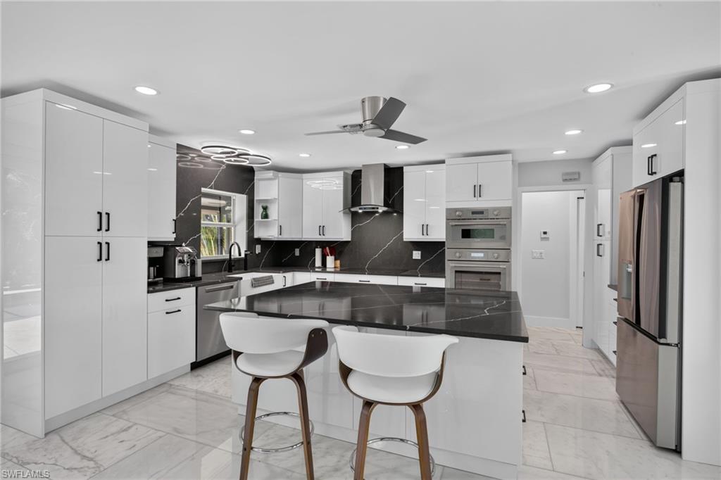 Quartz counters, backsplash, and huge island. Thermador wall oven, speed oven, and Freedom induction cooktop.