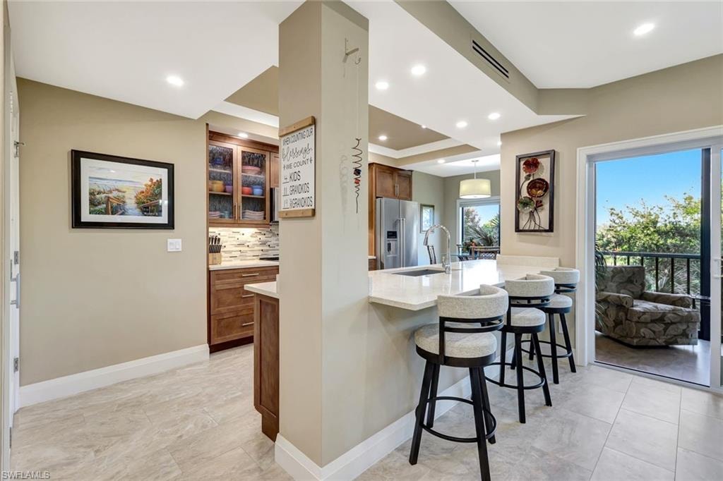 Bright, open kitchen with seating for three at upscale renovated kitchen
