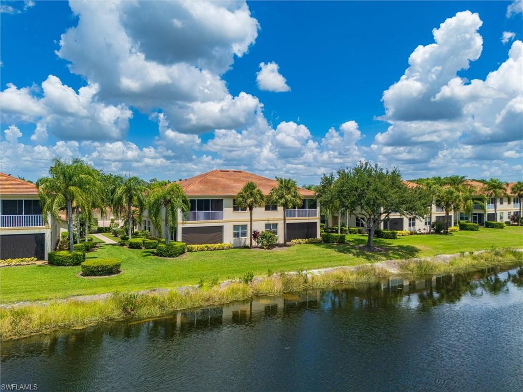 Waterfront community with mature landscaping, manicured lawns, and palm trees