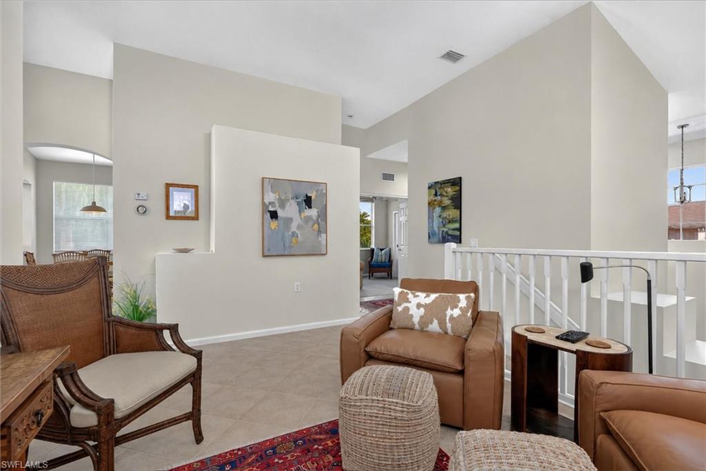 Open-concept living area with vaulted ceilings and neutral wall tones