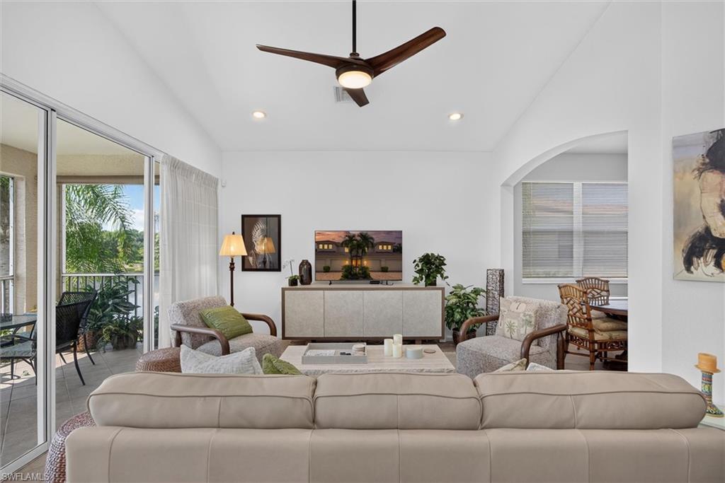 Vaulted ceiling living area featuring a contemporary ceiling fan, recessed lighting, and sliding glass doors leading to a private balcony