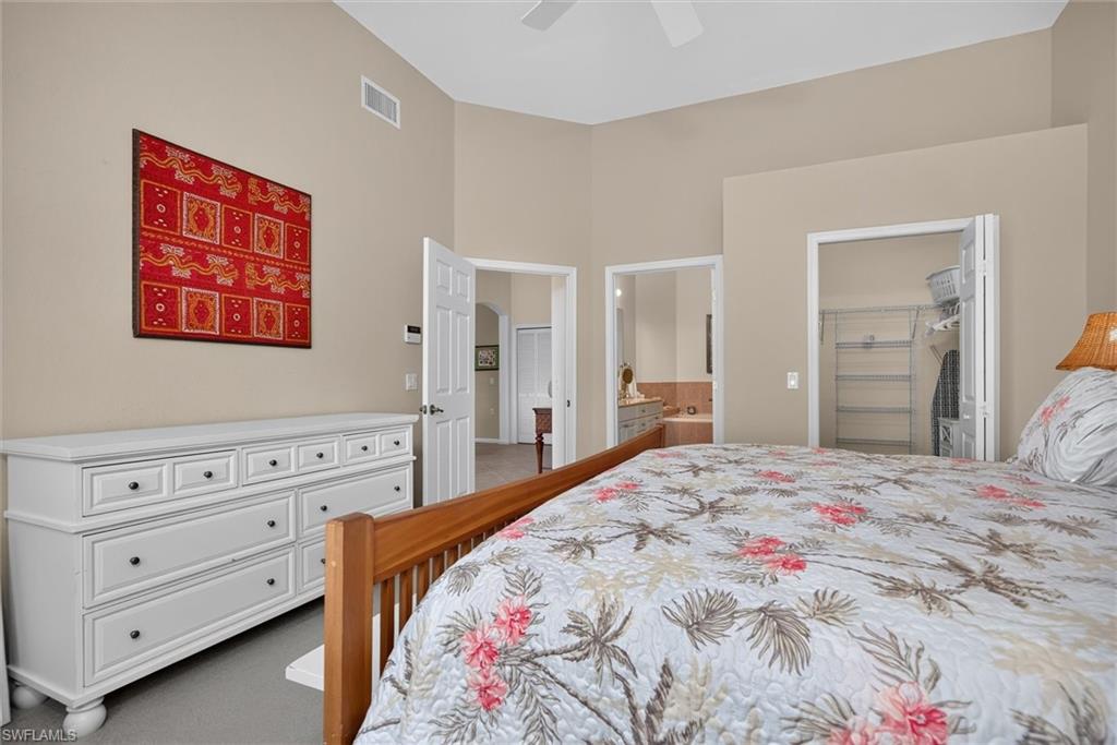 Bedroom featuring vaulted ceilings, a built-in closet system with shelving, and recessed lighting