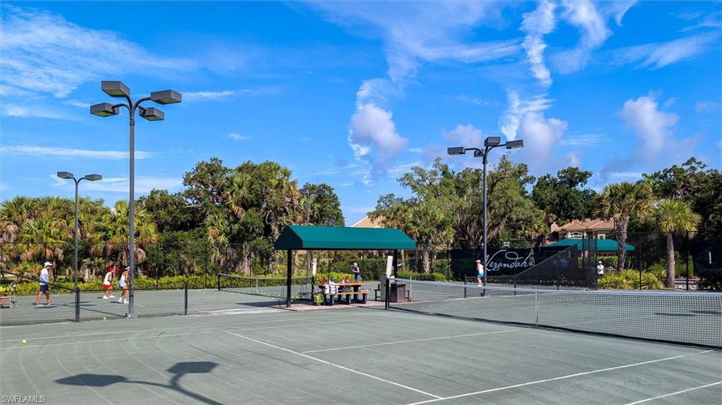 Tennis courts with light green playing surfaces and white line markings
