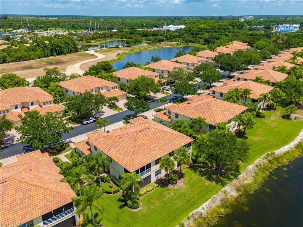 Residential community featuring Mediterranean-style residences with terra cotta tile roofs, lush landscaping, and water features