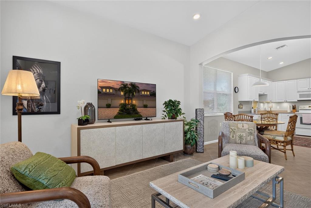Open concept living space featuring vaulted ceilings and neutral wall tones