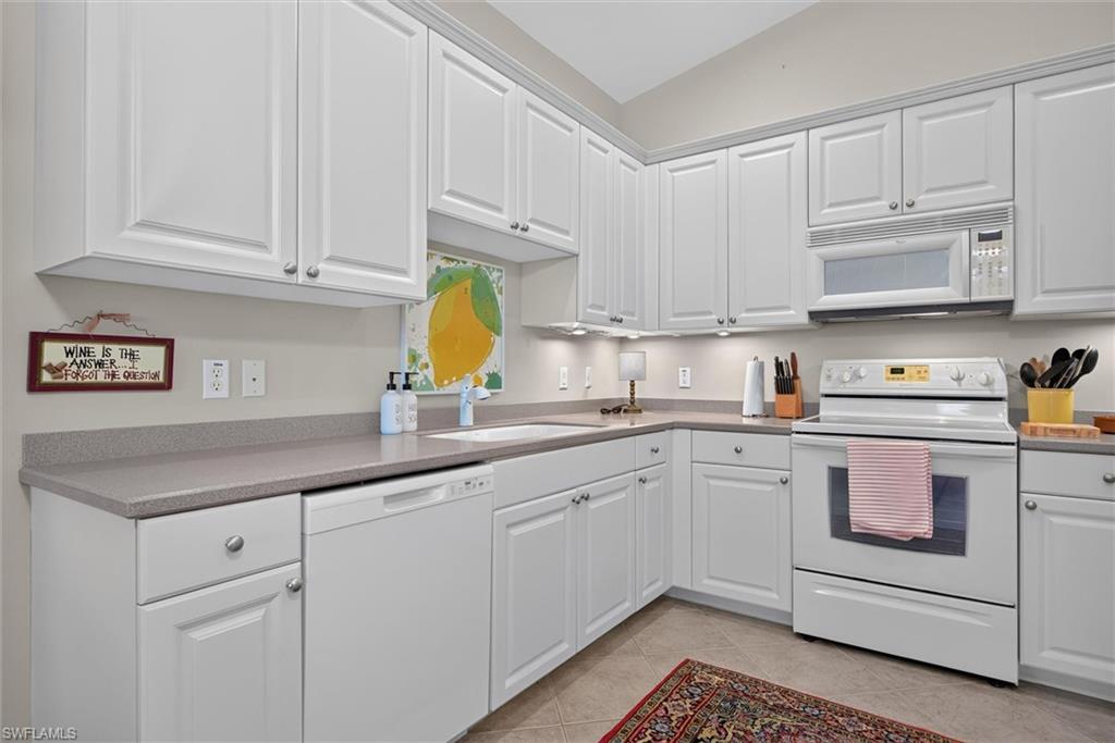 Kitchen featuring white cabinetry, grey countertops, undermount sink, built-in microwave, and an electric range