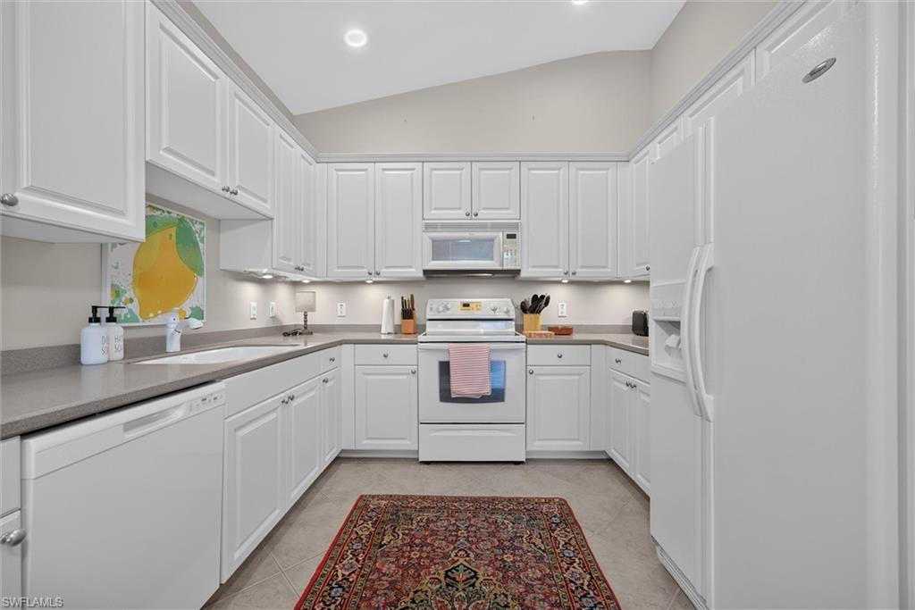 Kitchen featuring white cabinetry, gray countertops, recessed lighting, and a vaulted ceiling