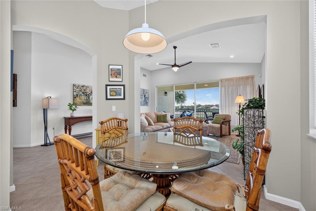 Dining area with a glass-top table, overhead pendant lighting, and arched entryways