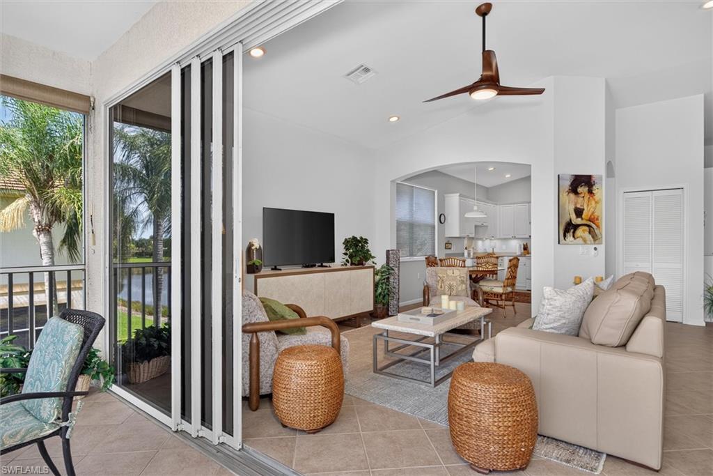 Expansive living area featuring tile flooring, a contemporary ceiling fan, and a wide arched entryway