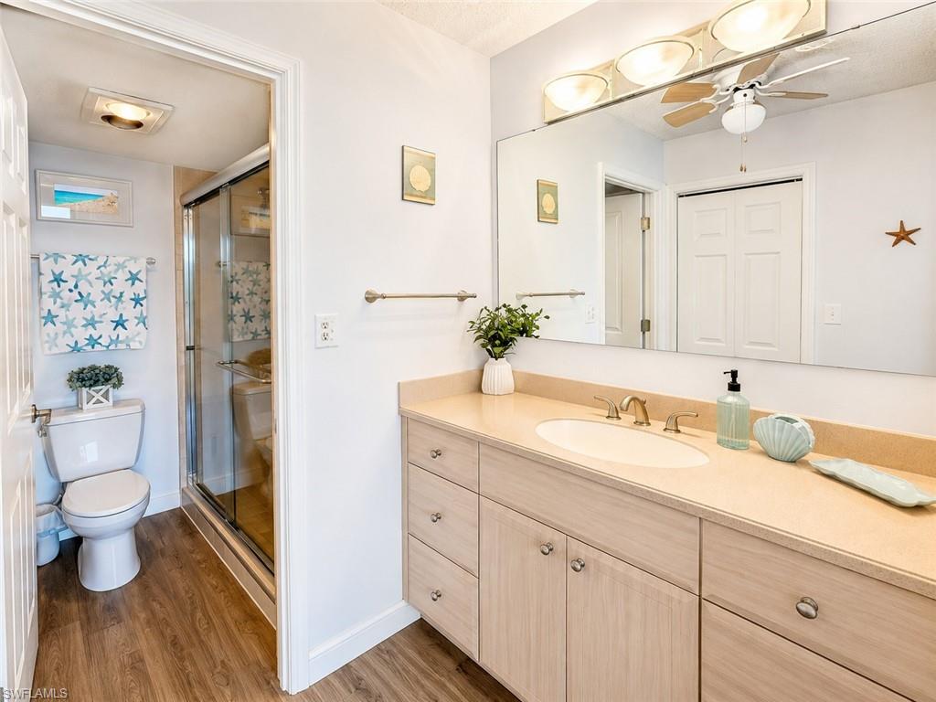 Bathroom vanity with integrated sink, light-toned countertop, and ample storage cabinetry