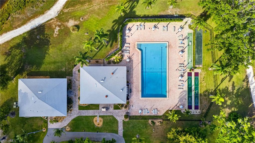 Community pool area featuring a rectangular swimming pool, surrounding patio, and lounge seating