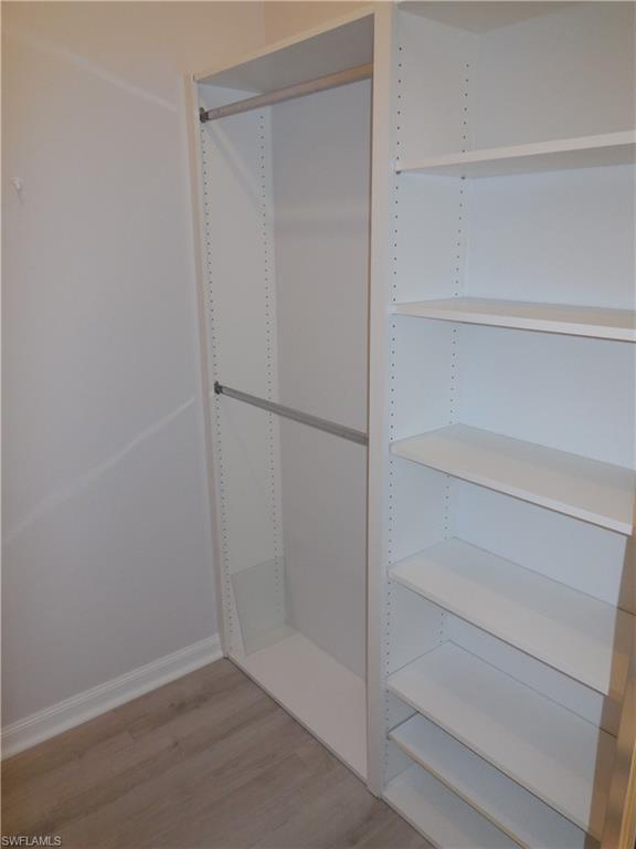 Custom closet system featuring white shelving and chrome hanging rods