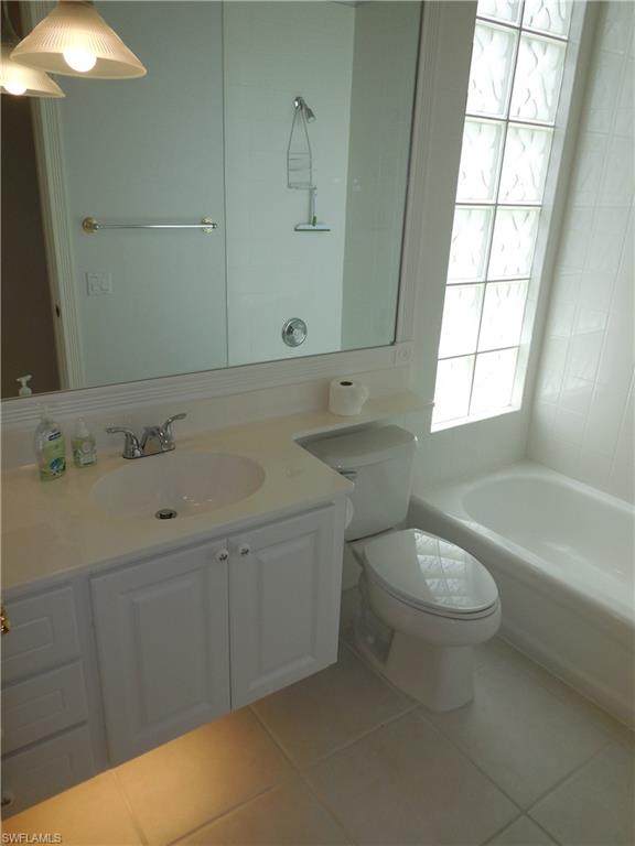 Bathroom featuring a white vanity with an integrated sink, polished chrome faucet, and storage cabinetry