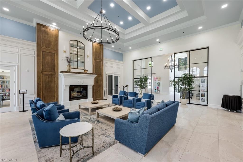 Spacious common area featuring a coffered ceiling with recessed lighting, an ornate fireplace with an intricate mantelpiece, and large black-framed glass partition walls