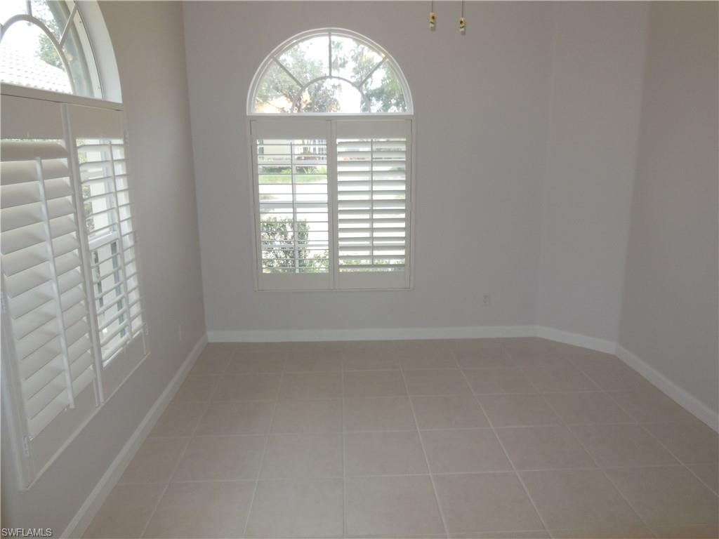 Interior space featuring neutral wall tones, square tile flooring, and white baseboards