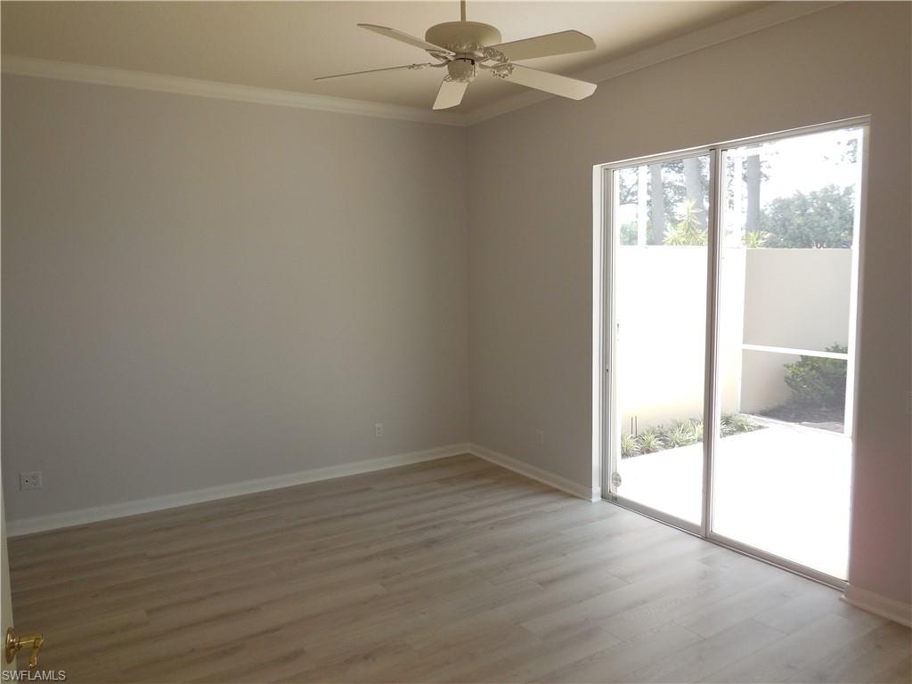 Room featuring wood-finish flooring, a ceiling fan, and crown molding