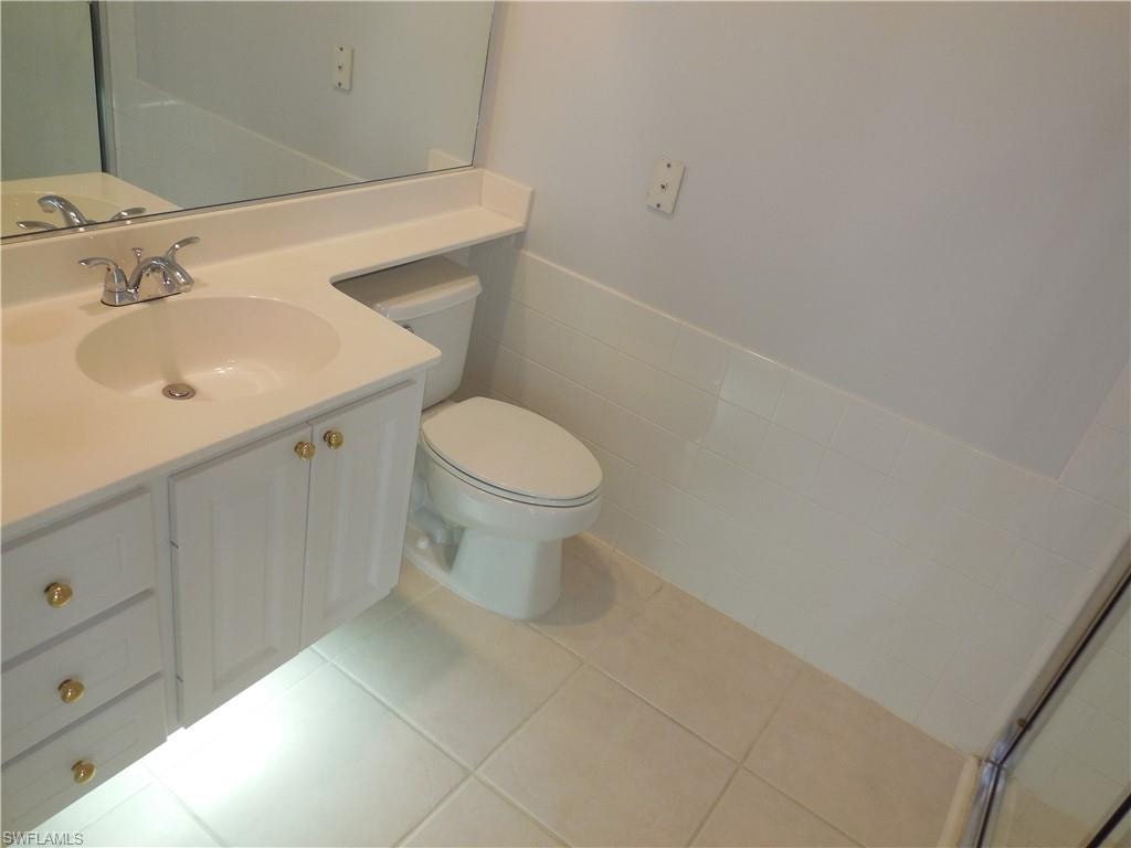 Vanity with integrated sink, chrome faucet, and gold-tone hardware