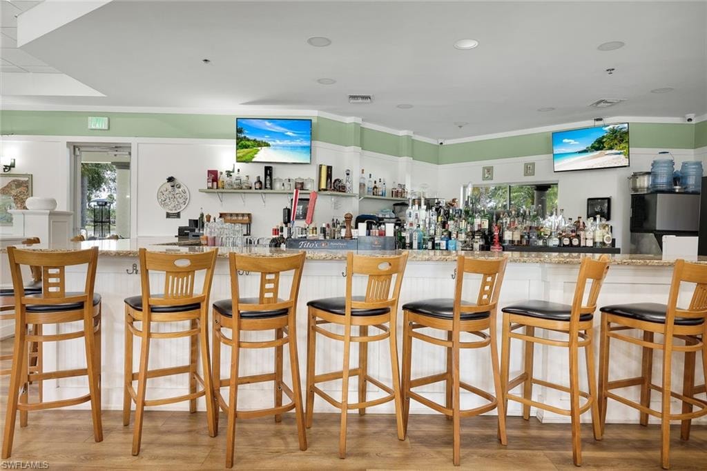 L-shaped bar with a stone-finish countertop and white paneled base