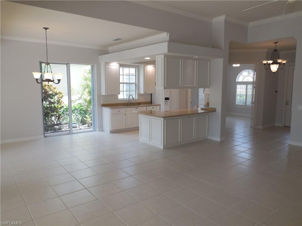 Open concept interior featuring light tile flooring and crown molding