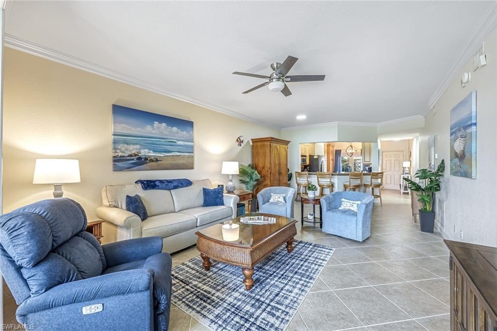 Living area with ceiling fan, ornamental molding, and light tile patterned floors