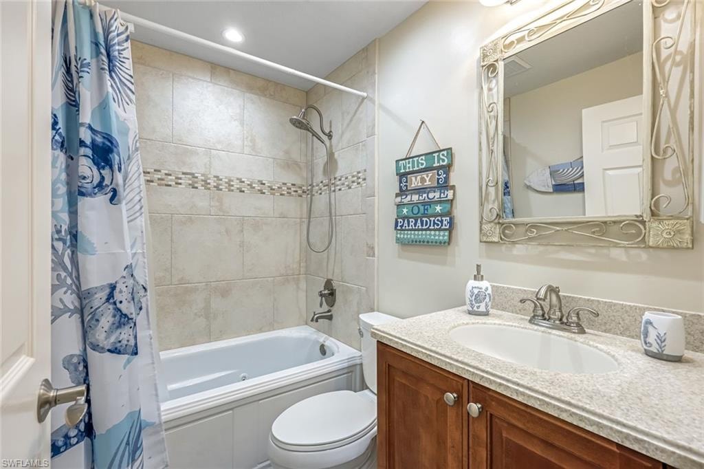 Bathroom featuring vanity and shower / bath combination with curtain