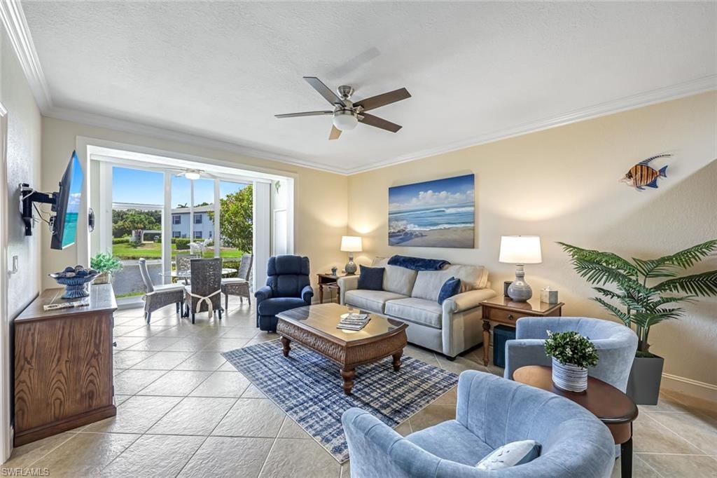 Living room with a ceiling fan, crown molding, and a textured ceiling