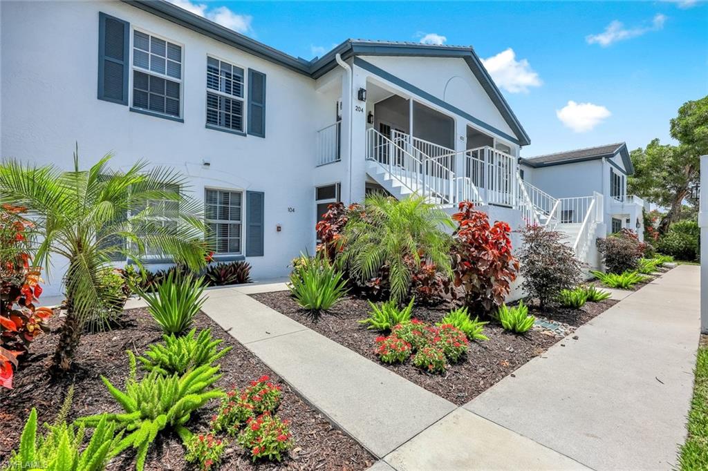 Multi unit property featuring stairs, stucco siding, and a sunroom