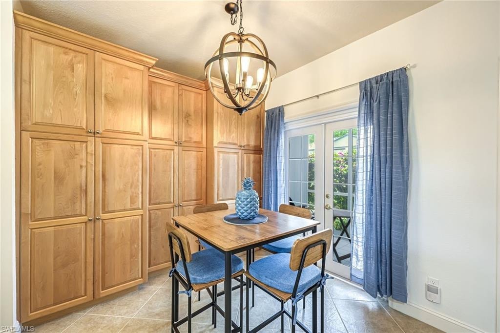 Dining area with french doors, a chandelier, and light tile patterned floors
