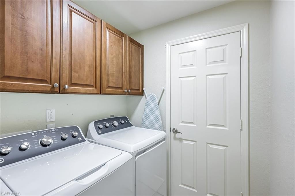 Laundry room featuring washing machine and clothes dryer and cabinet space