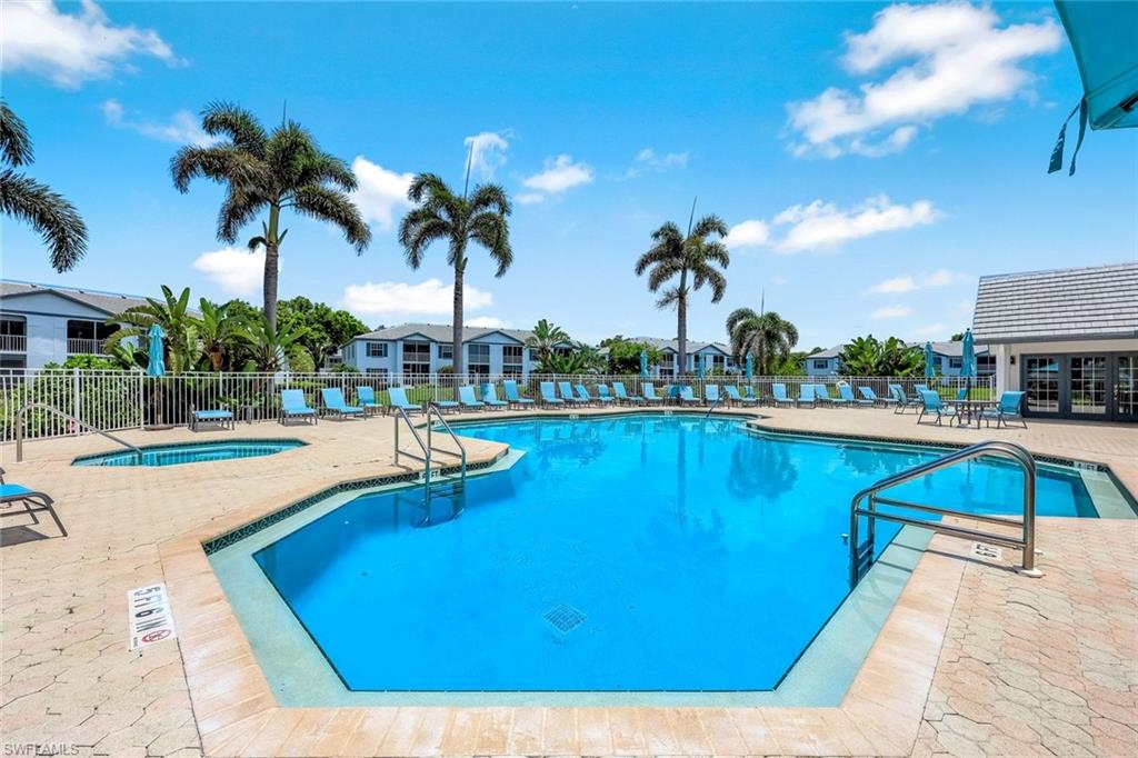 Community pool featuring a patio, a hot tub, and a residential view