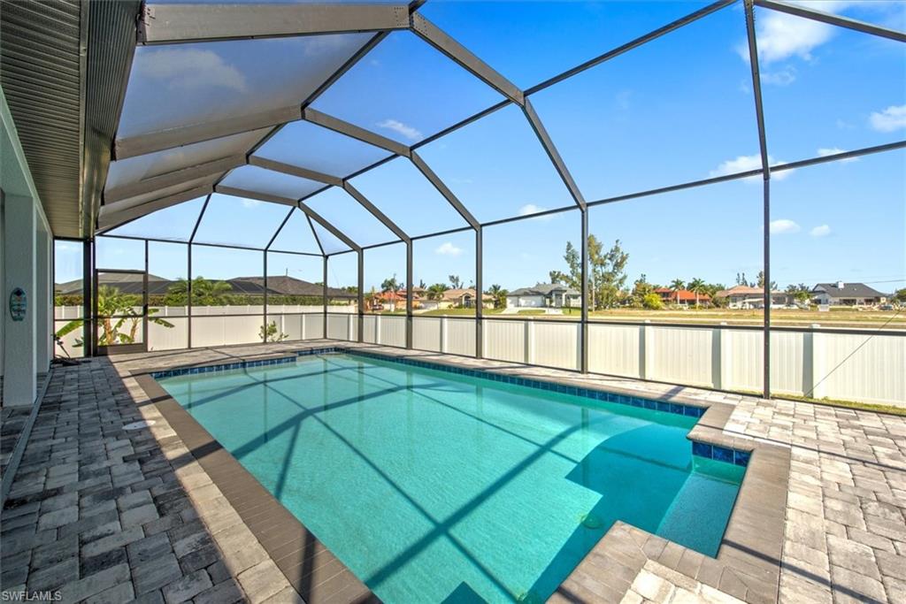 View of swimming pool featuring glass enclosure and a patio area