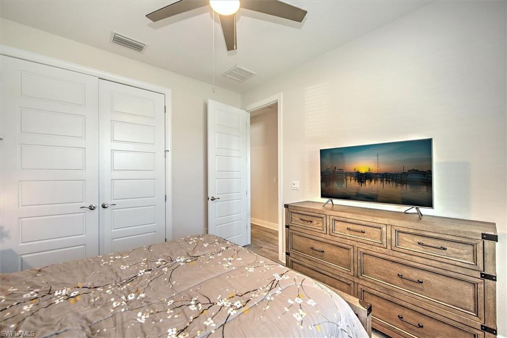 Bedroom with ceiling fan, a closet, and wood-type flooring