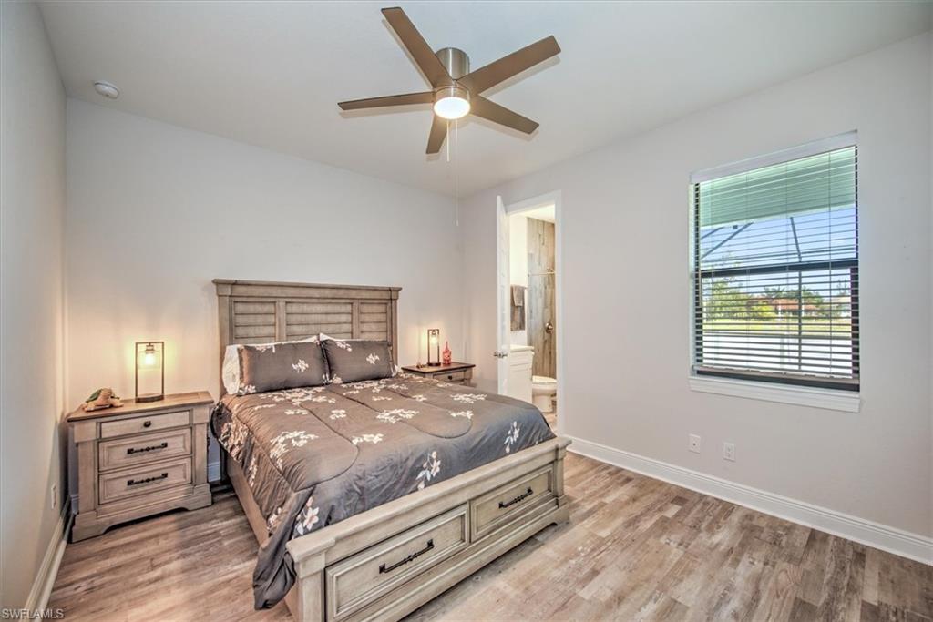 Bedroom featuring ceiling fan, light hardwood / wood-style flooring, and connected bathroom