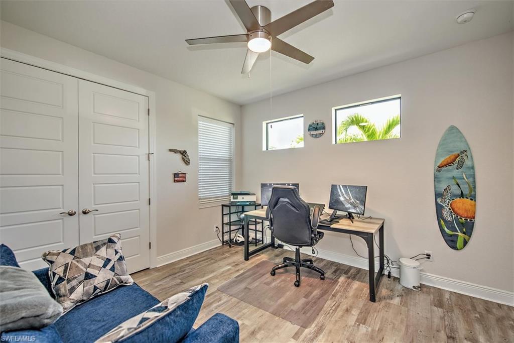 Home office featuring a wealth of natural light, ceiling fan, and light wood-type flooring