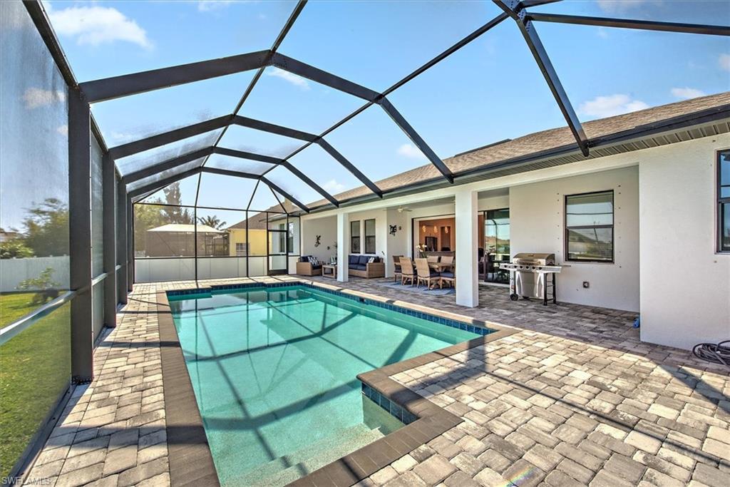 View of swimming pool with grilling area, a lanai, and a patio area