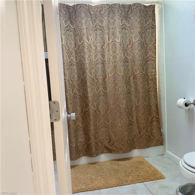 Primary bathroom with shower/ tub, toilet, and tile