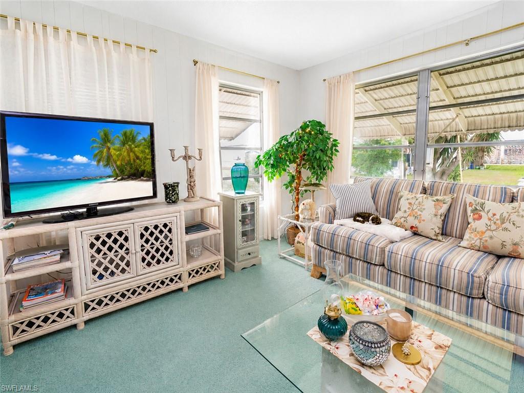 Living space featuring light blue-green carpeting and white paneled walls