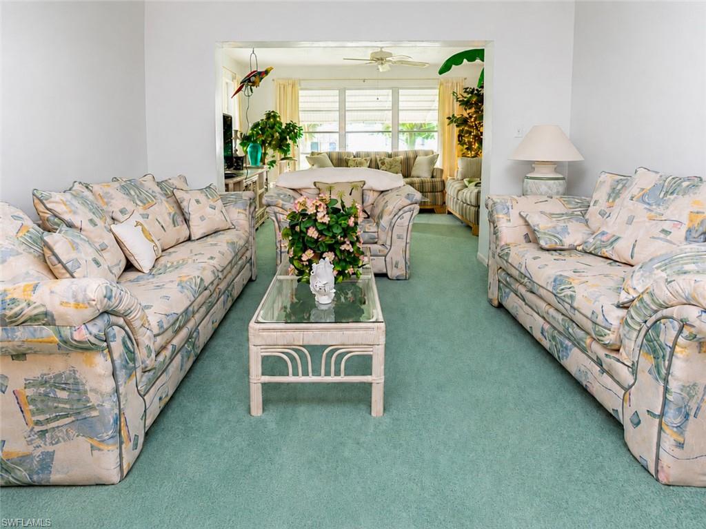 Carpeted living space featuring an open archway to an additional area