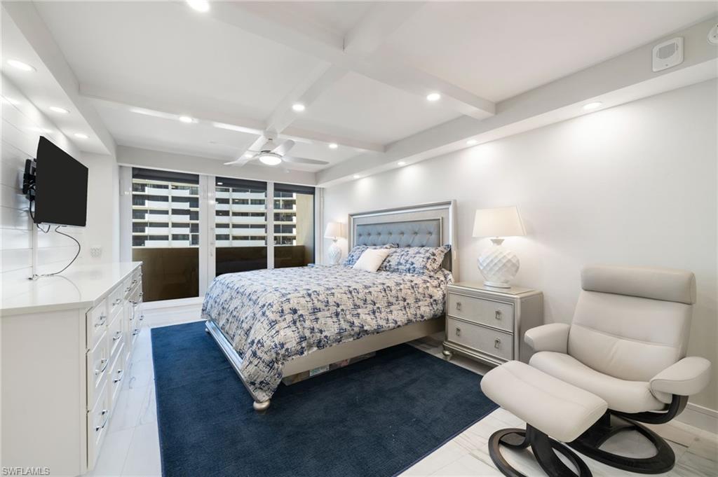 Tiled bedroom featuring beam ceiling, ceiling fan, and coffered ceiling